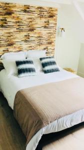 a bedroom with a large bed with blue and white pillows at LE VINTAGE 50 m de la plage mer en baie de Somme in Cayeux-sur-Mer