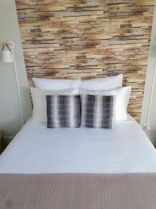 a bedroom with a white bed with pillows at LE VINTAGE 50 m de la plage mer en baie de Somme in Cayeux-sur-Mer