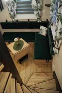 ein Wohnzimmer mit einem grünen Sofa und einem Tisch in der Unterkunft HARCÓWKA in Złoty Stok