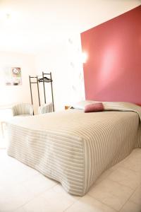 1 dormitorio con 1 cama blanca grande y pared roja en La ferme de la chassagne en Devrouze