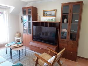 un soggiorno con grande TV e tavolo di Atico con terraza y piscina comunitaria a Ribadeo