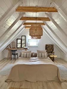- une chambre mansardée avec un grand lit dans l'établissement Kiskacsa Dörgicse, à Mencshely