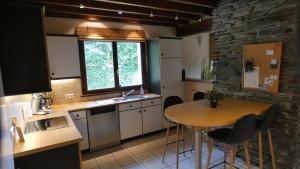 a kitchen with a table and a sink and a counter at Gîte La Borbotte in Malmedy +13 photos