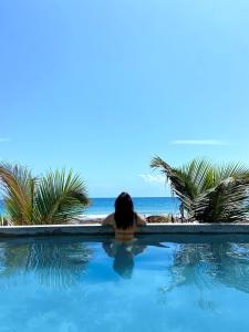 une femme assise dans une piscine donnant sur l'océan dans l'établissement Playa Esperanza Tulum, à Tulum