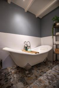 bañera blanca en una habitación con pared en City House Grande Madame Agaath, en Leeuwarden