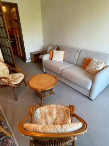 a living room with a couch and a table and chairs at Studio calme avec terrasse vue mer in Pléneuf-Val-André