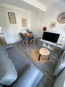 a living room with a couch and a table at L'Emile Zola in Saint-Quentin