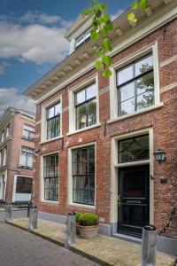 a brick building with windows on a street at City House Grande Madame Agaath in Leeuwarden