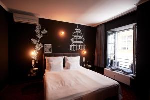 a bedroom with a large bed and a chandelier at WDREI Hotel in Munich