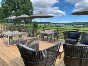 una terrazza con tavoli, sedie e ombrelloni di Älvstalodges a Jättendal