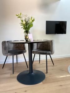 a table and two chairs with a vase of flowers at Ambiance in Hollum