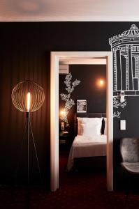 慕尼黑的住宿－WDREI Hotel，一间卧室配有一张床、一盏灯和一把椅子