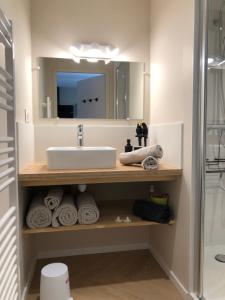 La salle de bains est pourvue d'un lavabo, d'un miroir et de serviettes. dans l'établissement VUE SUR REMPARTS - Coeur de Vannes- 2CH, à Vannes