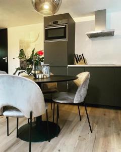 a kitchen with a table and chairs in a kitchen at Ambiance in Hollum