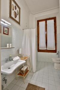 Baño blanco con lavabo y aseo en MADAMA GUEST HOUSE en Florencia