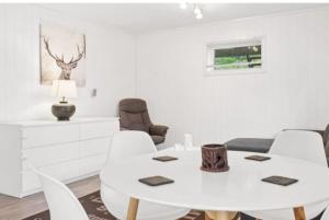 a white dining room with a white table and chairs at Lovely 1 bedroom downstairs condo with free parking place in Svolvær