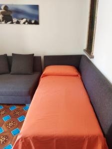 a couch with an orange bed in a room at Casa Vacanza Dante in Nurachi +10 photos