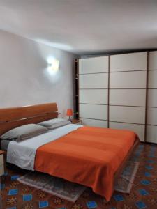 a bedroom with a large bed with an orange blanket at Casa Vacanza Dante in Nurachi