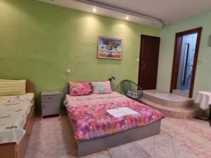 a bedroom with a bed and a green wall at Vila Anastas in Ohrid