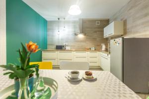 a kitchen with a table with a vase of flowers at Gościniec Przywidzki in Przywidz