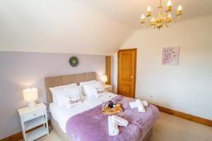 a bedroom with a bed with a tray of food on it at Morea Cottage - 2 Bed in Horning