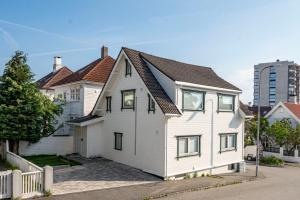 een wit huis met een bruin dak bij Homelike and Cozy Apt close to City Centre in Stavanger