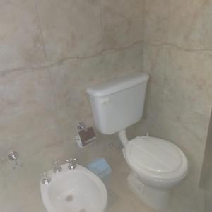 y baño con aseo blanco y lavamanos. en Departamento centrico carlos paz en Villa Carlos Paz