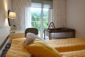 a bedroom with a bed and a window with a piano at Apartament Bukovy Wisła in Wisła