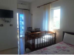 a bedroom with a crib and a window and a bed at Vila Ester in Ksamil