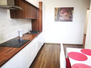 a kitchen with white cabinets and a wooden counter top at Apartament Ogarna II in Gdańsk