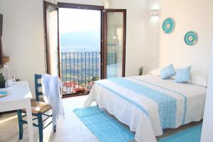 a bedroom with a bed and a large window at Sa Domm'e Galleria in Baunei