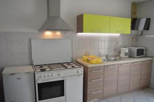 kuchnia z białą kuchenką i zlewem w obiekcie Rooms & Apartments Kvasić w Krku
