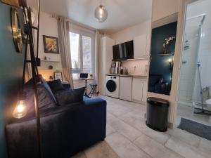 Una sala de estar con un sofá y una cocina. en Cosy studio in heart of Montmartre, en París 30 fotos más