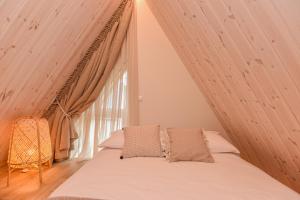 Bett in einem Zimmer mit einem großen Fenster in der Unterkunft Jaukus pajūrio namelis BOHO BEACH HOUSE su baseinu in Palanga