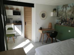 a bedroom with a bed and a table and a kitchen at Studio au calme vue sur garlaban in Roquevaire