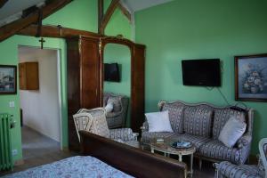 a living room with two couches and a table at LA DEMEURE DE LA JUINE in Morigny-Champigny