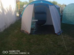 a tent in the grass with a table in it at Tente chez l'habitant in Saint-Jean-de-Monts