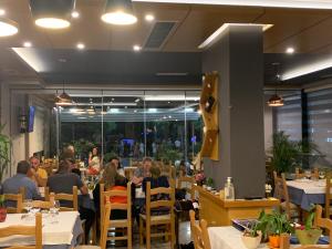 a group of people sitting at tables in a restaurant at Bledi Hotel in Shëngjin