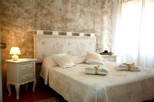 una camera da letto con un letto bianco con due asciugamani di Villa Vittoria a San Teodoro