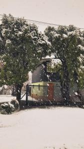 a bus is parked in the snow next to trees at CABAÑA LA SUREÑA in San Martín de los Andes
