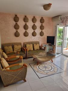 a living room with a couch and chairs and a tv at Apartments Rales in Sveti Stefan