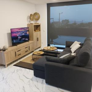 a living room with a couch and a flat screen tv at Casiña de Cris in Boiro