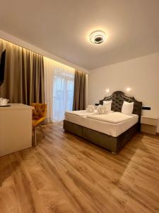 a bedroom with a large bed and a wooden floor at Vila Noblesse in Sovata