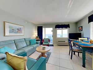 uma sala de estar com um sofá azul e uma mesa em Perdido Skye #56 em Perdido Key