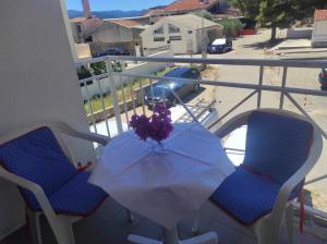 Apartment Sun في كليك: طاولة على شرفة مع إناء من الزهور