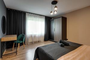 a bedroom with a bed and a desk and a window at Loft House Double Apartament z ogródkiem in Rybnik