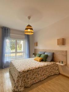 ein Schlafzimmer mit einem großen Bett und einem großen Fenster in der Unterkunft Samil primera línea de playa in Vigo