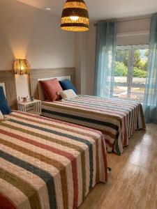 a hotel room with two beds and a window at Samil primera línea de playa in Vigo