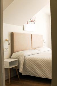 um quarto com uma cama branca e uma janela em Hostal montevideo em Nigrán