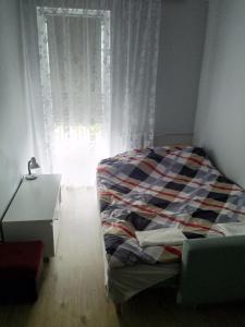 a bedroom with a bed in front of a window at Apartament Blisko Plaży in Gdańsk